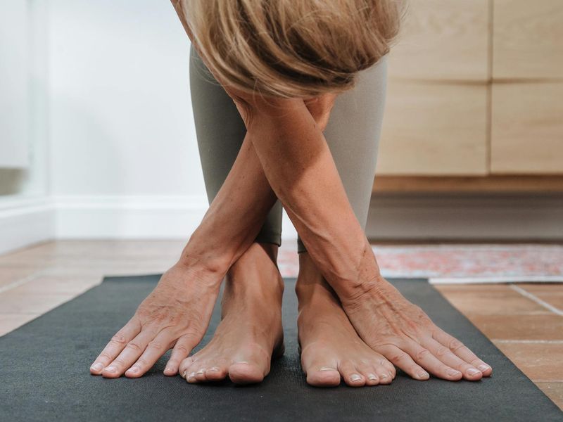 Woman stretching her arms gracefully on a yoga mat.